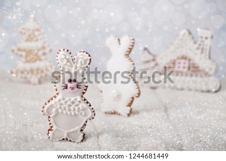 Christmas background with gingerbread in the form of hares on white knitted fabric