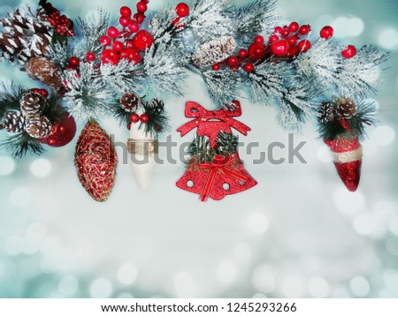 christmas bell with fir tree branch cones and snow on background with garland lights