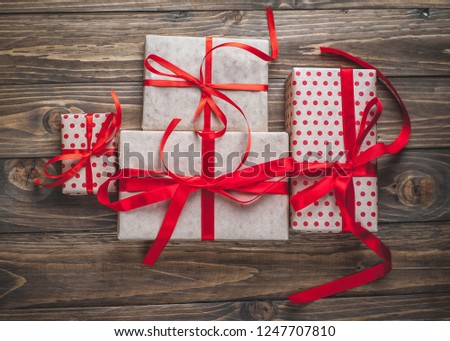 
gift boxes with red ribbon on wooden table