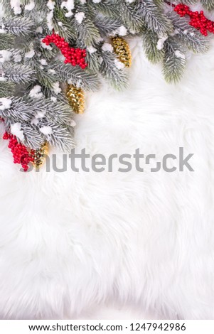 Border from red berries and branches fur tree on  white textured  background. Decorative christmas composition. Selective focus. Place for text. View from above. Vertical image.