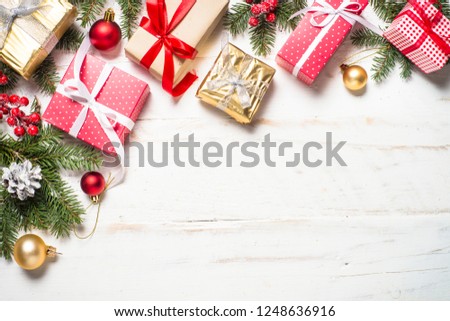 Red and Gold present box and decorations on white wooden background. Top view with copy space.