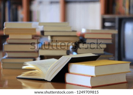 Close-up of books opened on library table Book stack is the background selective focus and shallow depth of field
