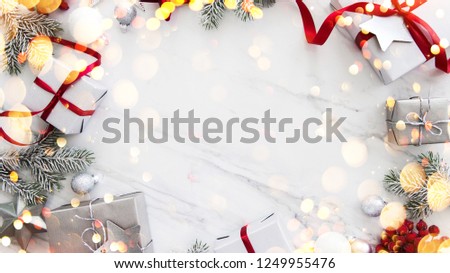 Christmas silver and red gifts and ornaments on white marble background top view. Merry Christmas greeting card, frame. Winter xmas holiday theme. Noel. Happy New Year. Flat lay