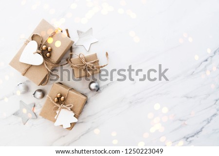 Christmas handmade gift boxes on white marble background top view. Merry Christmas greeting card, frame. Winter xmas holiday theme. Noel. Happy New Year. Flat lay