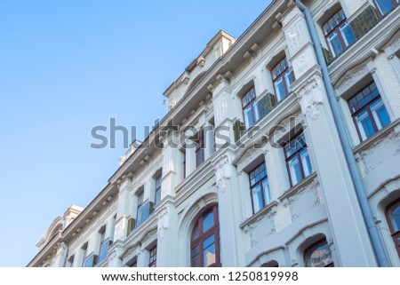 Beautiful facade of an old building with lots of windows, against a blue sky