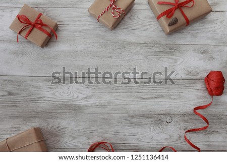Present boxes , fir cone and red ribbon roll on white wooden background. Gift packing concept. Paper wrap, rope, ribbon, parcel, eco packing, craft, handmade