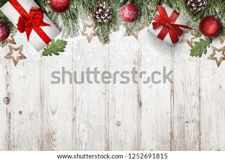 Frosty Christmas decorations and gifts covered with snowflakes on white wooden background. Christmas background with free space for text