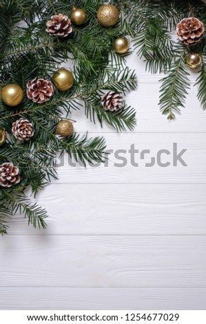 Christmas composition. Spruce branches with cones and Christmas toys of gold color on a white background. Made in flat style.