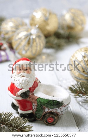 Christmas composition with a toy Santa Claus on the background of fir branches and Christmas balls