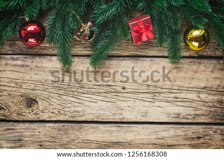 Christmas background with fir tree branches and traditional ornaments on a rustic wooden board