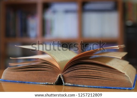 Close up of old books opened in the library bookshelf is the background selective focus and shallow depth of field