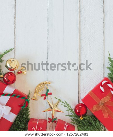 Christmas red gift boxes with green pine and decorating ornaments on white wood panel background, border design with copy space,or new year frame composition,top view 