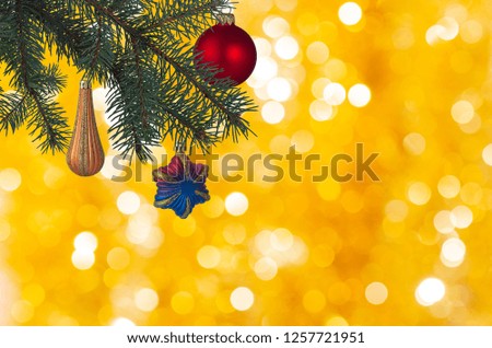 Christmas balls blue gold cherry on a green Christmas tree with a card on a gold blurred background