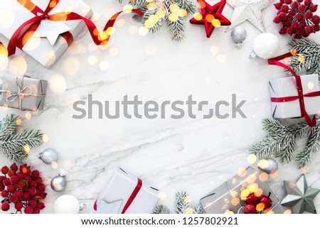 Christmas silver and red gifts and ornaments on white marble background top view. Merry Christmas greeting card, frame. Winter xmas holiday theme. Noel. Happy New Year. Flat lay