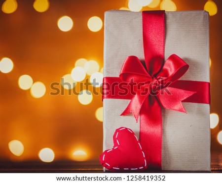 holiday gift box and heart hape toy on Fairy Lights background