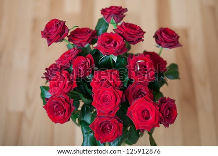 Big bunch of red roses with wedding rings