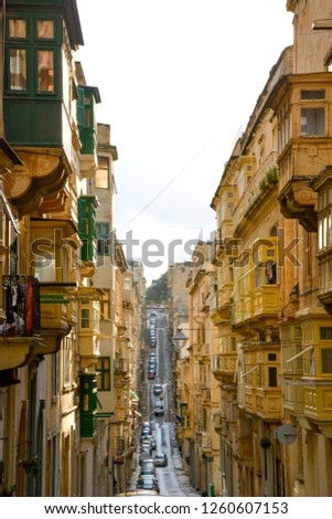 A view of old Valletta street with a residental houses with a traditional Maltese style multicolored balconies, Malta.