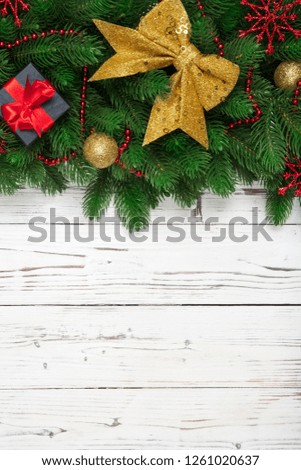 Christmas winter decoration vertical with fir branches and gift box on wooden white board background.