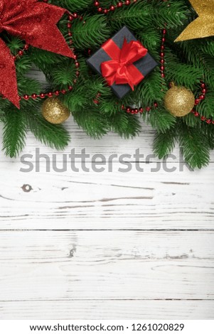 Christmas winter decoration vertical with fir branches and gift box on wooden white board background.