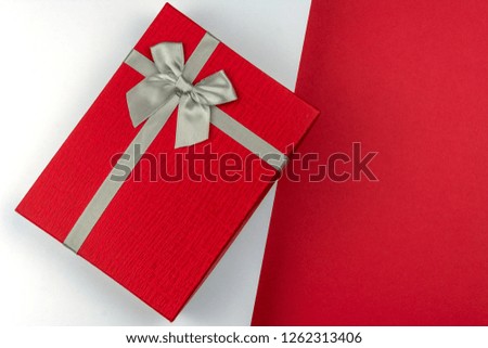 Beautiful Red gift box with bow on red and white background