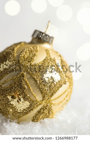 Christmas tree golden ornament ball in snow in winter forest. Sparkling garland bokeh lights. Pastel colors. New year greeting card poster banner template with copy space. Minimalist style