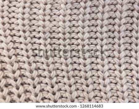 knitted carpet closeup. Textile texture, off white background. Detailed warm yarn. Knit cashmere, beige wool.
