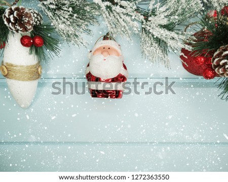christmas santa with fir tree branch cones and snow on background with garland lights
