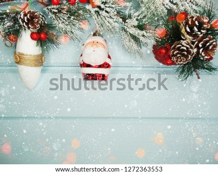 christmas santa with fir tree branch cones and snow on background with garland lights