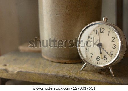 The white vintage clock alarm  near window light.