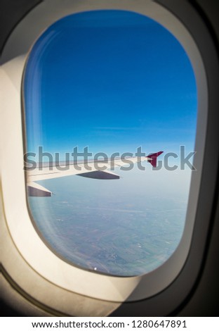 View from the window of an airplane in the blue sky 