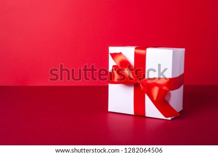Gift box for birthday, valentines day, christmas, wedding day. White box. Red tape or ribbon. Red background.