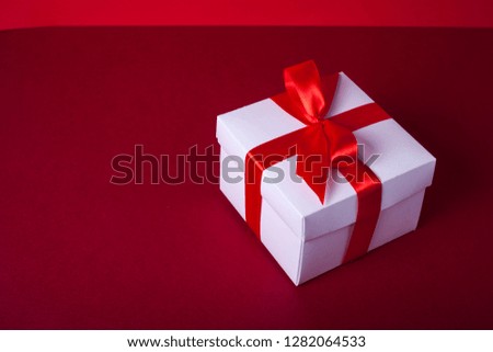 Gift box for birthday, valentines day, christmas, wedding day. White box. Red tape or ribbon. Red background.