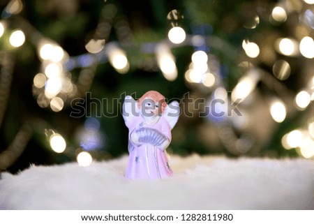 Christmas Angel on the background of Christmas trees and garlands.
