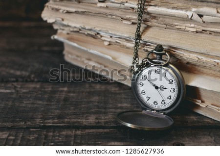 Pocket watch and stack of books on the writer desk. Back to school.