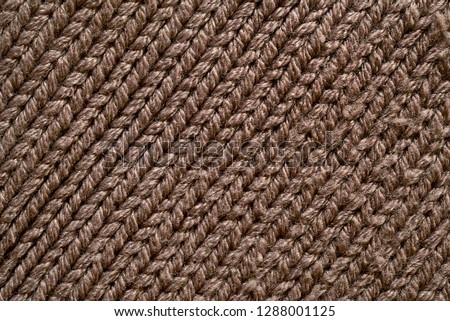 fabric texture. macro photography. a fragment of a knitted cloth with a visible weaving pattern and thread elements.