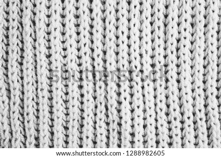 Black and white picture of knitted woolen fabric textile background. Vertical lines.