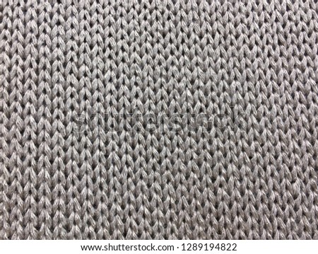 Creamy wool knitted warm clothes for the winter fabric texture background


