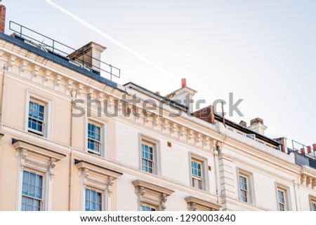 London neighborhood district of Pimlico with terraced housing balconies buildings old vintage historic traditional style flats roof with chimneys sun and sky