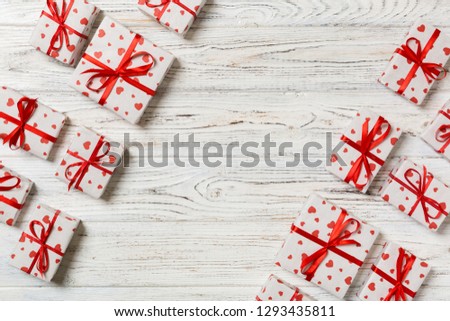 top view of various gift boxes. wrapped valentine or other holiday handmade present in paper with red ribbon and heart. Present box, decoration of gift on wooden table.