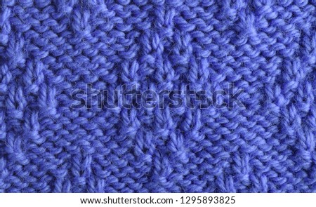 Blue wool yarn knitted texture with large stitches. Hand knitted 