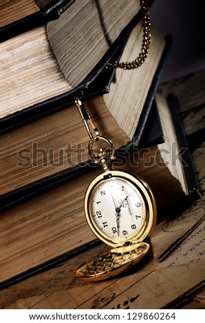 vintage pocket clock and old books