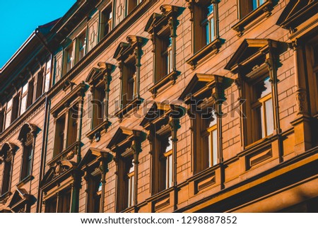 Old stone building with triangular architraves and tall windows with balconies in Prague, Czech Republic