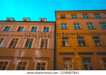 Windows and facades of two apartment blocks in Prague, Czech Republic in a low angle view under a clear blue sky