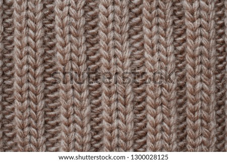 Light brown woolen knitted fabric texture. Macro.