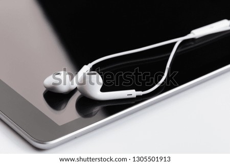 white earphones on tablet