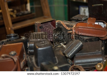 Antique Folding Camera with Bellows over a Pile of Old Cameras.