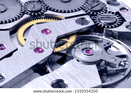 Gears of a mechanical watch close-up with blue toning