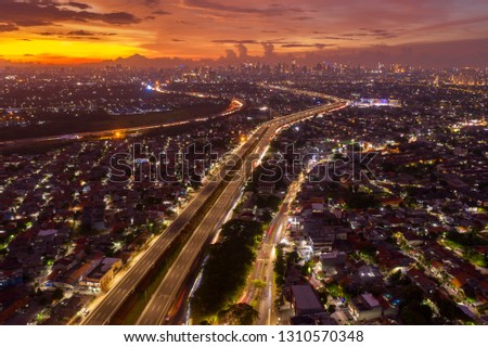 JAKARTA, Indonesia - February 06, 2019: Top view of Becakayu tollway with dense housing at dawn time in Jakarta, Indonesia