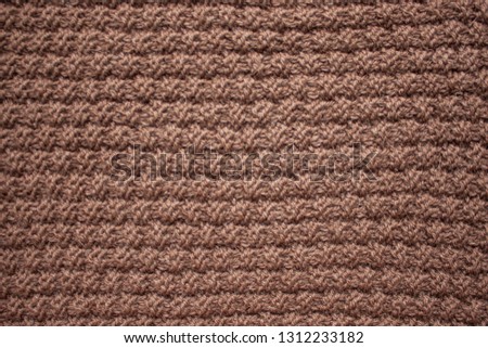 Knitting. Knitted scarf. Brown scarf. Hobby. Material background. Texture