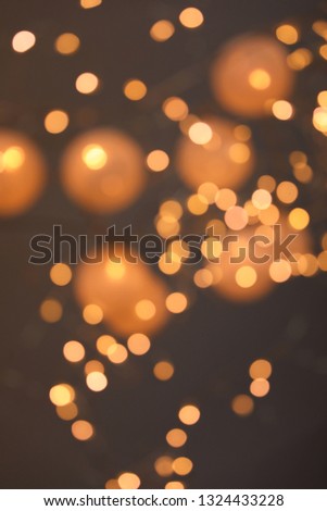 Blurred view of gold lights on dark background. Bokeh effect